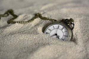 3d clock fallen in sand CGI image